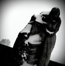 Une statue de Madone sous la neige dans un cimetière