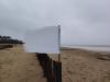 Drapeau blanc sur une plage battue par les vents